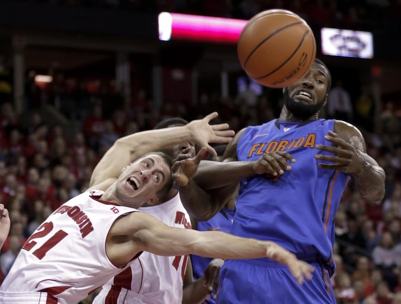 Wisconsin’s Josh Gasser (21) and Nigel Hayes vie for a rebound with Florida’s Patric Young during the first half of an NCAA college basketball game in Madison, Wisconsin. Andy Manis / AP Photo