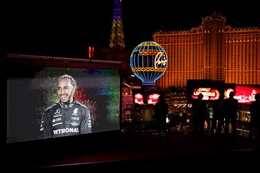 People watch as a recording of Mercedes driver Lewis Hamilton, of Britain, is projected onto a screen during a news conference announcing a 2023 Formula One Grand Prix auto race to be held in Las Vegas, Wednesday, March 30, 2022, in Las Vegas.  (AP Photo / John Locher)