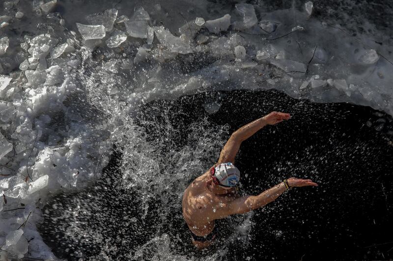 A winter swimming enthusiast swims in a frozen river on a cold winter day in Beijing, China. EPA