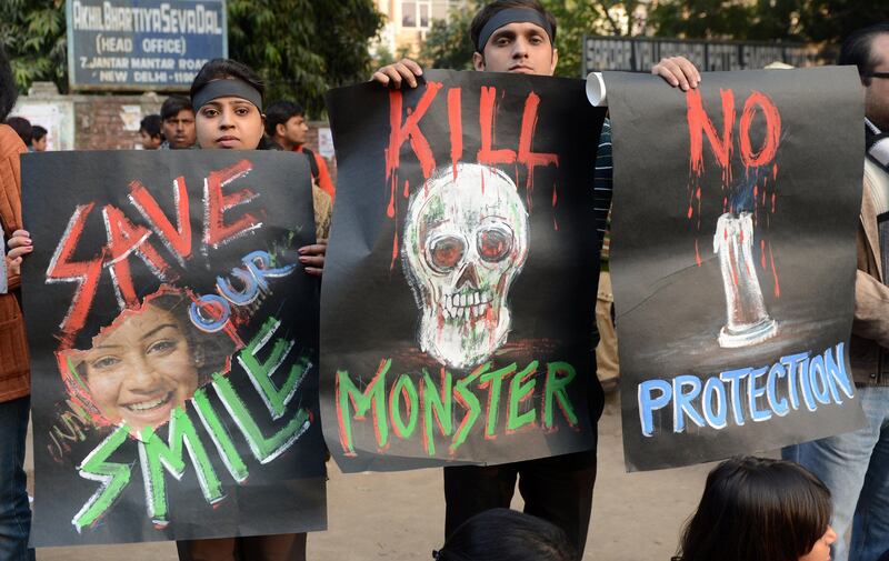 Indian protestors pose with placards during a rally against the gangrape of a student in New Delhi on December 30, 2012. The victim of a gang-rape and murder which triggered an outpouring of grief and anger across India was cremated at a private ceremony, hours after her body was flown home from Singapore. A student of 23-years-old, the focus of nationwide protests since she was brutally attacked on a bus in New Delhi two weeks ago, was cremated away from the public glare at the request of her traumatised parents. AFP PHOTO/RAVEENDRAN
 *** Local Caption ***  173983-01-08.jpg