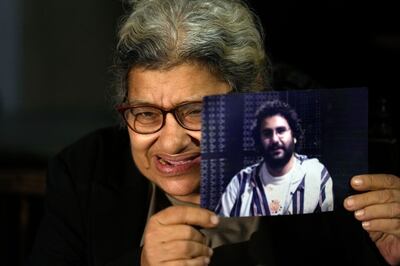Laila Soueif holds up a photo of her son Alaa Abdel Fattah, a jailed Egyptian activist who this week escalated a hunger strike to demand his release. AP