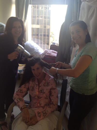 Friends blow-dry Amy's hair in the hospital