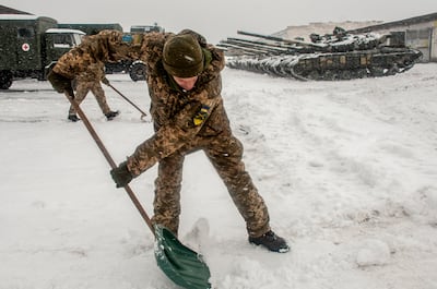 Ukrainian soldiers clear snow at a military unit close to Kharkiv. AP