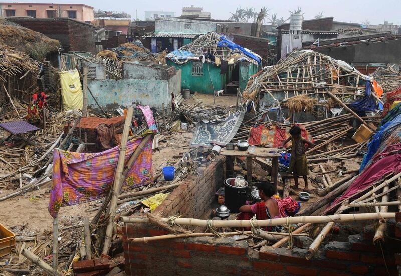 TOPSHOT - An Indian woman sits in the debris with a child in a storm-damaged building in Puri in the eastern Indian state of Odisha on May 4, 2019, after Cyclone Fani swept through the area. Cyclone Fani, one of the biggest to hit India in years, barrelled into Bangladesh on May 4 after leaving a trail of deadly destruction in India.

 / AFP / Dibyangshu SARKAR
