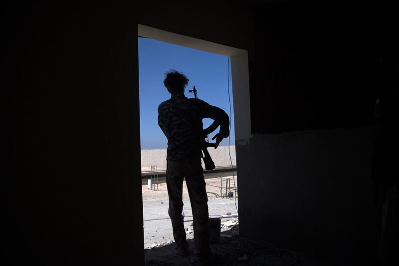 A fighter loyal to the internationally-recognised Government of National Accord (GNA) stands in a doorway on the frontline during clashes with forces loyal to strongman Khalifa Haftar, in Espiaa, about 40 kilometres (25 miles) south of the Libyan capital Tripoli on April 29, 2019.  Fierce fighting for control of Libya's capital that has already displaced tens of thousands of people threatens to bring a further worsening of humanitarian conditions, a senior UN official has warned. / AFP / Fadel SENNA
