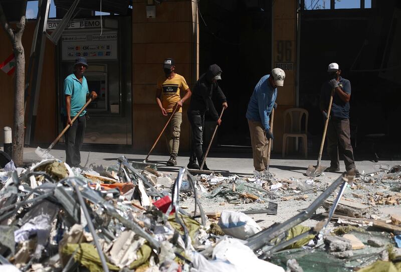 People clean debris from the street following Tuesday's blast in Beirut's port area, Lebanon August 9, 2020. REUTERS/Hannah McKay