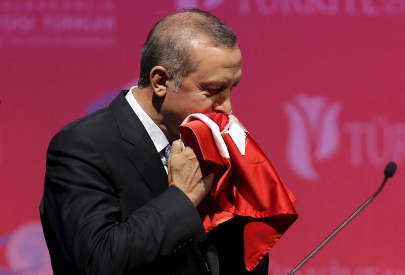 Turkey's president Recep Tayyip Erdogan kisses a handmade Turkish flag given to him as a gift from a Ugandan university student during a graduation ceremony in Ankara on June 11, 2015. Umit Bektas/Reuters