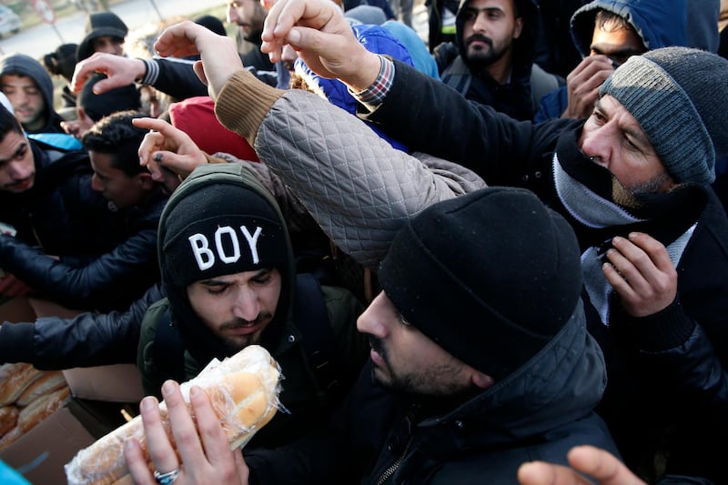 Migrants receive food distributed by non-governmental organizations near the Pazarkule border gate in Edirne, at the Turkish-Greek border. AP Photo