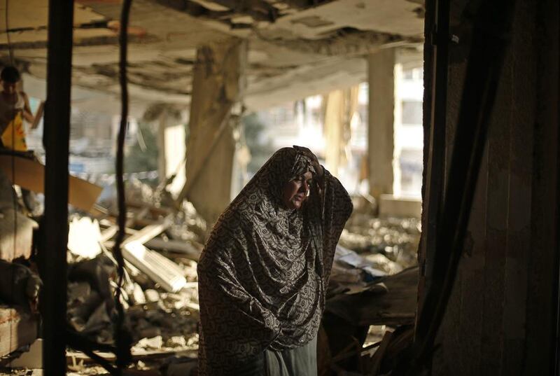 A Palestinian woman in the ruins of her Gaza City house after an Israeli air strike. Photo: Reuters / Mohammed Salem 