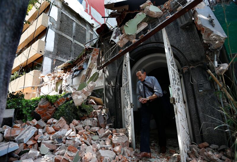 A man walks out of the door frame of a building that collapsed after an earthquake, in the Condesa neighbourhood of Mexico City. Marco Ugarte / AP Photo