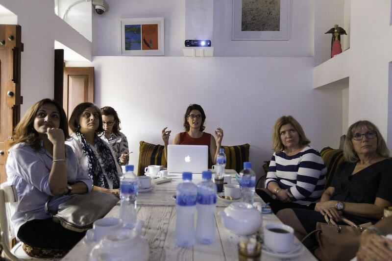 Art historian Rose Balston, centre, tells an audience the story of oriental carpets in renaissance paintings, at XVA Gallery in Dubai. Christopher Pike / The National