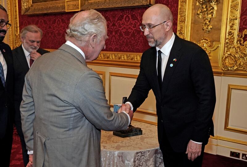 King Charles shakes hands with Mr Shmyhal during the reception. Reuters