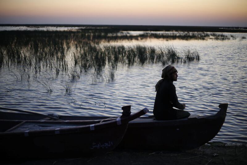 An Iraqi man sits on a boat at the Chebayesh marsh in Dhi Qar province, Iraq. Reuters
