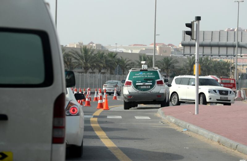 DUBAI, UNITED ARAB EMIRATES , April 18– 2020 :- Dubai Police checking vehicle entering from Manama street to International City in Dubai. Only two entrance are open for vehicles coming from Al Awir road before the Dragon Mart 1 and Manama Street to International City in Dubai.  Dubai is conducting 24 hours sterilisation programme across all areas and communities in the Emirate and told residents to stay at home. UAE government told residents to wear face mask and gloves all the times outside the home whether they are showing symptoms of Covid-19 or not.  (Pawan Singh / The National) For News/Online