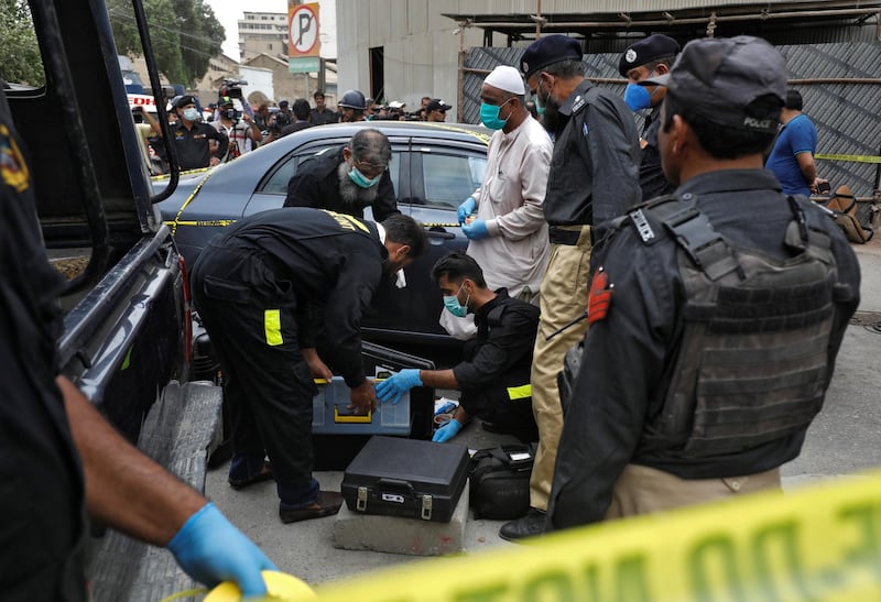 Members of Crime Scene Unit of Karachi Police prepare to survey the site of an attack at the Pakistan Stock Exchange entrance in Karachi. REUTERS