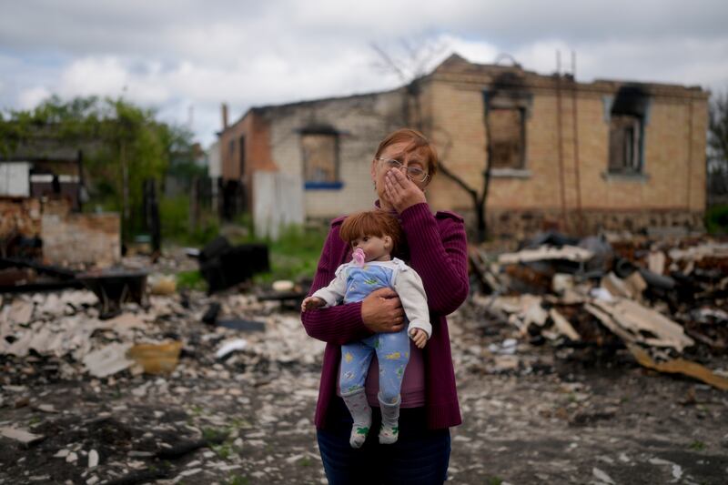 Nila Zelinska holds a doll belonging to her granddaughter that she found in her destroyed house in Potashnya, on the outskirts of Kyiv, in May 2022