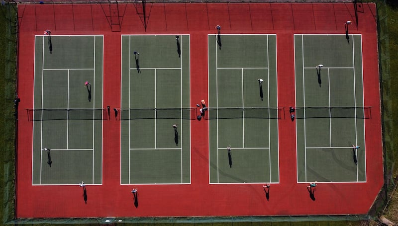 People playing tennis at the Mersey Bowman Lawn Tennis Club in Liverpool. The relaxation of the stay-at-home order means organised sports have returned to England.