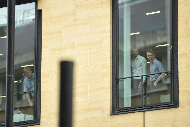 Members of staff look out from the Deutsche Bank building in London.  Getty