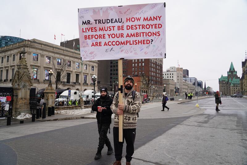 A man holds a sign criticising Canadian Prime Minister Justin Trudeau. Willy Lowry / The National