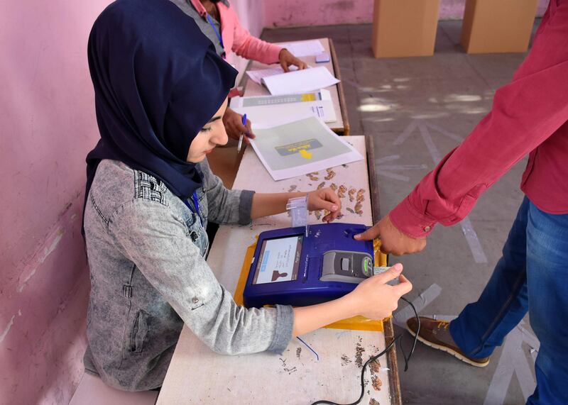 An Iraqi voter has his biometric voting card checked with his fingerprint upon arriving at a poll station in the northern multi-ethnic city of Kirkuk on May 12, 2018, as the country votes in the first parliamentary election since declaring victory over the Islamic State (IS) group. Polling stations opened at 7:00 am for the roughly 24.5 million registered voters to cast their ballots across the conflict-scarred nation. / AFP / Marwan IBRAHIM
