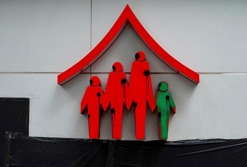 Logo of the Family Planning clinic was painted with black marks on the chests of the family icons in Wan Chai, Hong Kong. AP