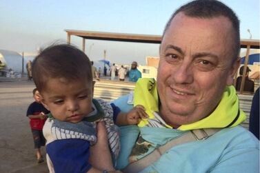 British aid worker, Alan Henning, holding a child in a refugee camp on the Turkish-Syrian border before he was taken hostage and murdered by Isis. AFP