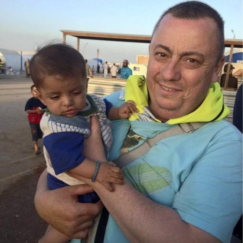 This handout image received from Britain's Foreign and Commonwealth Office on September 15, 2014 shows British aid worker, Alan Henning holding a child in a refugee camp on the Turkish-Syrian border. Prime Minister David Cameron vowed Sunday, September 14, 2014, that Britain would hunt down the killers of an aid worker beheaded by the Islamic State, which he described as the "embodiment of evil". Cameron said Britain was prepared to "take whatever steps are necessary" after David Haines became the third Western hostage to be beheaded by the militants in less than a month. IS released a video Saturday showing Haines' killing and a death threat against another British captive, Alan Henning. AFP PHOTO/FOREIGN AND COMMONWEALTH OFFICE
-RESTRICTED TO EDITORIAL USE - MANDATORY CREDIT " AFP PHOTO / FOREIGN AND COMMONWEALTH OFFICE" - NO MARKETING NO ADVERTISING CAMPAIGNS - DISTRIBUTED AS A SERVICE TO CLIENTS- (Photo by - / FOREIGN AND COMMONWEALTH OFFICE / AFP)