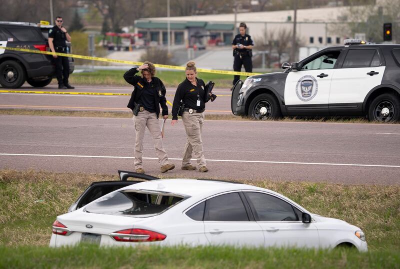 Two Bureau of Criminal Apprehension agents begin investigating the scene of an officer-involved shooting, in Burnsville, Minnesota. AP