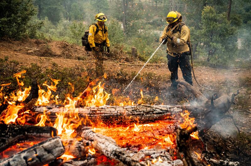 Firefighters mop up hot spots while battling the Oak Fire in California on July 25. AP