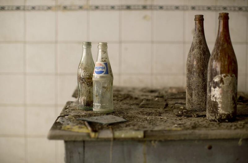 Coca-Cola and Pepsi bottles gather dust at a former cafe.