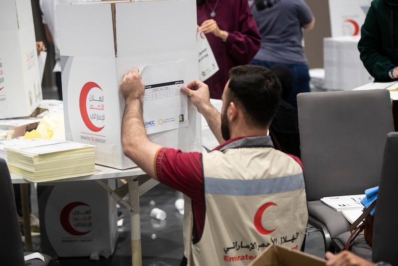 Volunteers pack food, blankets and other essential goods at the Dubai Exhibition Centre, at Expo City