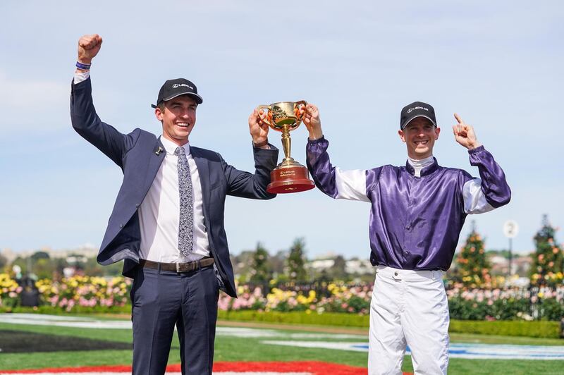 Jye McNeil and stable representative Mark Power celebrate with the trophy after their horse, Twilight Payment, won the Melbourne Cup. AFP