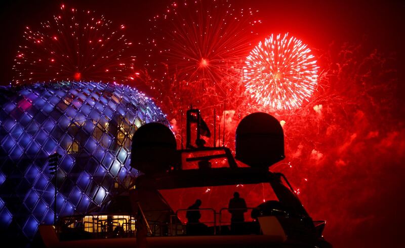 People are silhouetted on the flybridge of a yacht as fireworks illuminates the sky over the Yas Viceroy luxury hotel on the first day of the Muslim holiday of Eid Al Fitr at the Marina on Yas Island, Abu Dhabi. Ali Haider / EPA