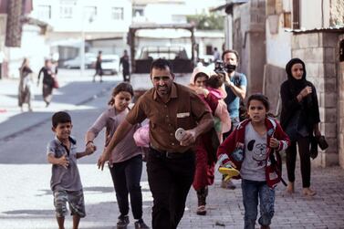 People run to take cover after mortars fired from Syria, in Akcakale, Turkey, Thursday, Oct. 10, 2019.  AP 