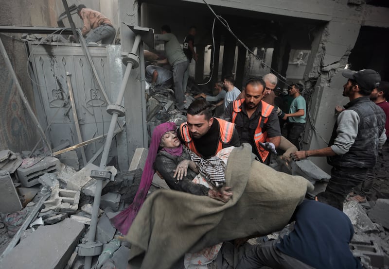 Palestinian rescuers evacuate an injured woman following an Israeli air strike in Khan Younis refugee camp. AP