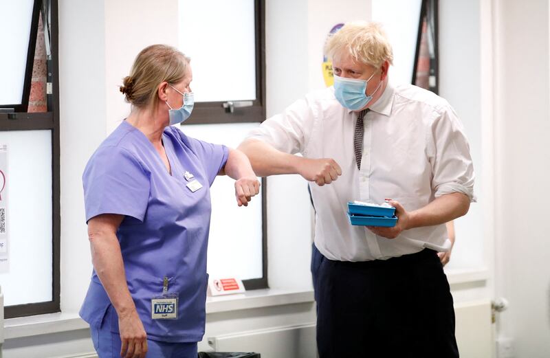 Britain's Prime Minister Boris Johnson greets a member of vaccination staff with an elbow bump during a visit to a Covid-19 vaccine centre in Northampton. The elbow bump is another trend to emerge during the pandemic. Getty Images