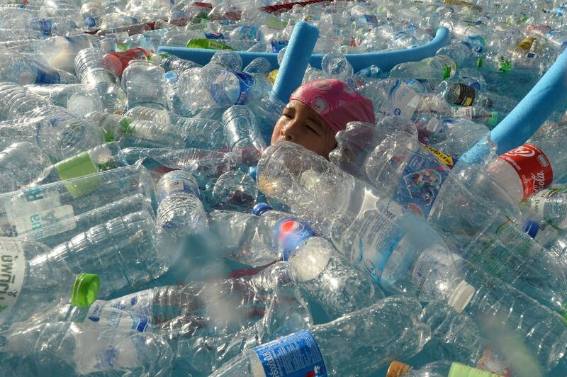 A Thai child swims in a pool filled with plastic bottles during an awareness campaign to mark the World Oceans Day in Bangkok. AFP