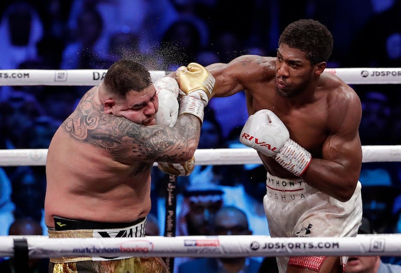 Defending champion Andy Ruiz Jr., left, takes a right cross to the face during his fight against Britain's Anthony Joshua in their World Heavyweight Championship contest at the Diriyah Arena, Riyadh, Saudi Arabia early Sunday Dec. 8, 2019. (AP Photo/Hassan Ammar)