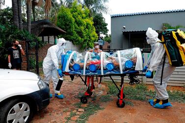 Paramedics move a suspected coronavirus patient enclosed inside an isolation chamber from his home in Pretoria, South Africa. AFP