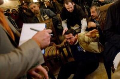 (FILES) A picture taken on December 14, 2008 shows Iraqi journalist Muntazer al-Zaidi taken to the ground after throwing his shoes at then US president George W. Bush during a joint press conference with Iraqi Prime Minister Nuri al-Maliki in Baghdad. An Iraqi court jailed Zaidi on March 12, 2008 for three years. Zaidi, a 30-year-old television journalist, had pleaded not guilty at the hearing in the Iraq Central Criminal Court to assaulting Bush during his farewell visit to Iraq last year. AFP PHOTO/SAUL LOEB *** Local Caption ***  Nic347156.jpg