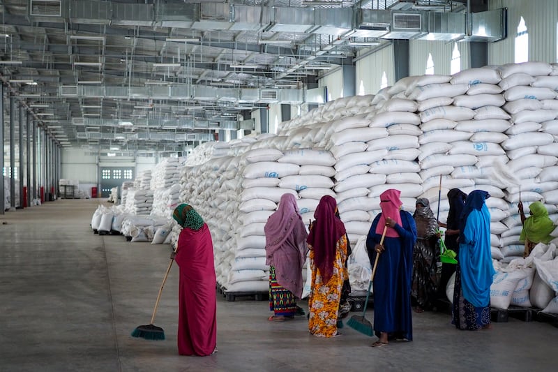Workers clean the floor as sacks of food earmarked for the Tigray and Afar regions sit in piles in a warehouse of the World Food Programme in Semera, the regional capital for the Afar region in Ethiopia. AP