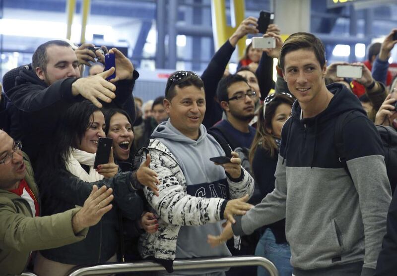 Fernando Torres greets fans upon his arrival at Barajas International Airport in Madrid, Spain on Tuesday for his re-introduction with Atletico Madrid. Javier Lizon / EPA