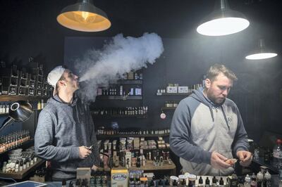 BRISTOL, ENGLAND - DECEMBER 30:  Mitchell Baker (L) who works at the Vapour Place a vaping shop in Bedminster, exhales vapour produced by an e-cigarette as shop owner Jon Bartlett serves a customer on December 30, 2016 in Bristol, England. Recent figures released by the e-cigarette industry has claimed that there as many as 1700 vaping shops across the country, with two new ones opening each day catering for the estimated three million vapers in the UK. The popularity of e-cigarettes has boomed in the last ten years, as it is seen by many as a healthier alternative to traditional cigarettes, however some critics say the devices can carry the same risks as smoking especially as the long term affects are yet to be known.  (Photo by Matt Cardy/Getty Images)