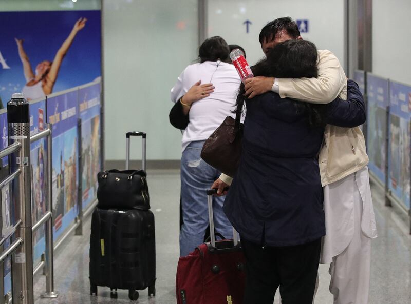 People among the first evacuees from Kabul hug as they arrive at Frankfurt International Airport, Germany.