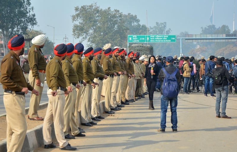Indian policemen and media personnel wait for the return of Indian pilot at India-Pakistan border at Wagah. AP Photo