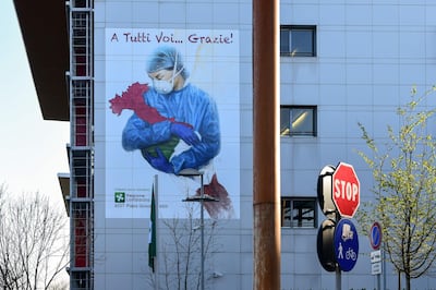 A mural by artist Franco Rivolli Art, depicting a nurse wearing a face mask, with wings behind her back and cradling Italy, is pictured on a wall of the Papa Giovanni XXIII Hospital in Bergamo, Lombardy, on March 16, 2020. RESTRICTED TO EDITORIAL USE - MANDATORY MENTION OF THE ARTIST UPON PUBLICATION - TO ILLUSTRATE THE EVENT AS SPECIFIED IN THE CAPTION
 / AFP / Piero Cruciatti / RESTRICTED TO EDITORIAL USE - MANDATORY MENTION OF THE ARTIST UPON PUBLICATION - TO ILLUSTRATE THE EVENT AS SPECIFIED IN THE CAPTION
