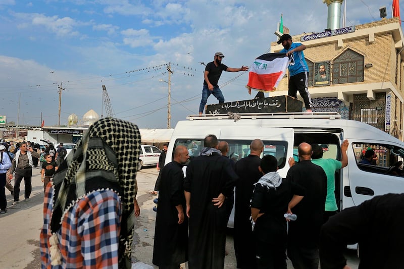 Mourners place a national flag on the coffin of Hassan Radi, a protester killed during anti-government demonstrations, during his funeral in Najaf, Ira. The latest bloody confrontations have killed more than 100 people in less than seven days. AP Photo
