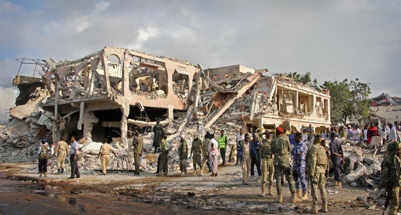 Somali security forces and others gather and search for bodies near destroyed buildings at the scene of Saturday's blast, in Mogadishu, Somalia Sunday, Oct. 15, 2017. The death toll from the huge truck bomb blast in Somalia's capital rose to over 50 Sunday, with more than 60 others injured, as hospitals struggled to cope with the high number of casualties, security and medical sources said. (AP Photo/Farah Abdi Warsameh)