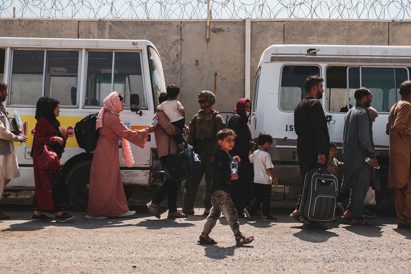 People preparing to leave Afghanistan board buses going to Hamid Karzai International Airport in Kabul on August 22. Photo: AFP