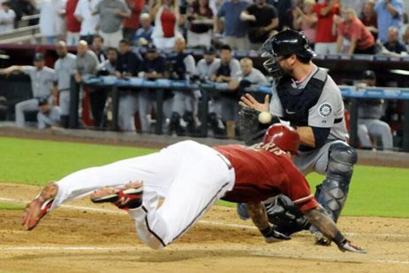 Ryan Roberts of the Arizona Diamondbacks slides safely into home plate ahead of a tag by Seattle's John Jaso